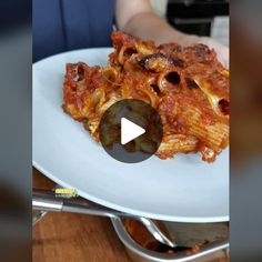 a white plate topped with lasagna covered in sauce