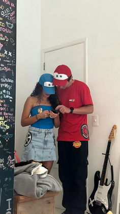 a man and woman standing next to each other in front of a chalkboard wall