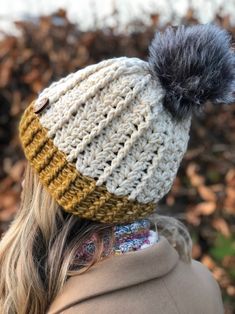 a woman wearing a knitted hat with a pom - pom