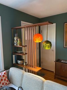 a living room filled with furniture and a dog laying on top of a couch next to a book shelf