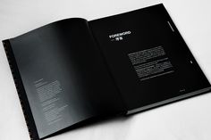 an open black book on a white surface with the words forward written in it's center