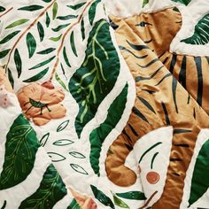 a close up view of a tiger and leaves pattern on a bed sheet that has been made to look like an animal