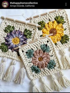 two crocheted placemats with flowers on them and tassels hanging from the handles