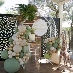 a giraffe is standing next to some balloons