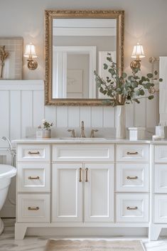 a bathroom with white cabinets and gold accents