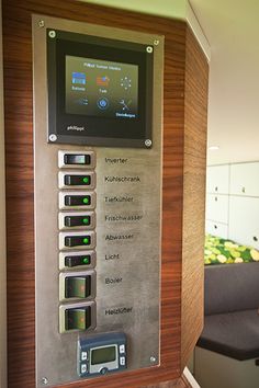 an elevator control panel with buttons and numbers on the wall in front of a couch