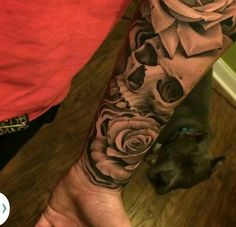 a man with a rose tattoo on his arm next to a black and white dog