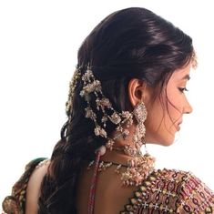 a woman with long hair wearing an elaborate head piece and jewelry on her back neck