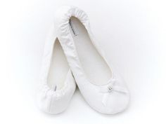 pair of white ballet shoes with satin bow