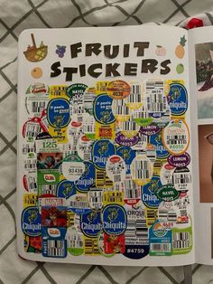 an open fruit sticker book sitting on top of a bed