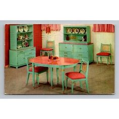 an old fashioned kitchen with green cabinets and red chairs