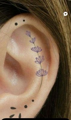 a close up of a person's ear with flowers on it