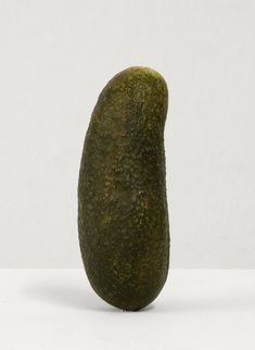 an odd looking green object sitting on top of a white countertop next to a wall