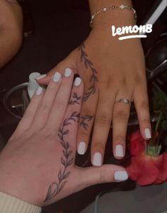 two hands with tattoos on their fingers and one has a rose tattooed on the other hand