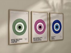 three posters hanging on the wall with an eyeball design in different colors and sizes