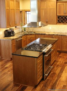 a kitchen with wooden cabinets and an island in the middle of the flooring area