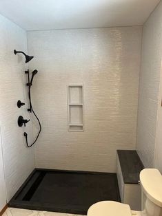 a white toilet sitting next to a shower in a bathroom under a window with no curtains