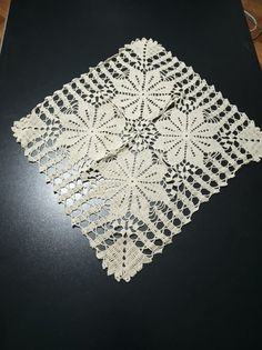 a white doily sitting on top of a black table