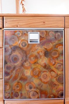 an old refrigerator is covered in rusted metal and wooden cabinets with drawers on each side