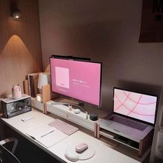 two computer monitors sitting on top of a desk