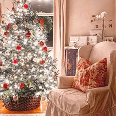 a living room with a christmas tree in the corner and a chair next to it