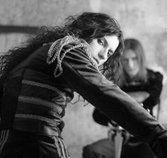 black and white photograph of two women sitting on chairs with one holding her hair back