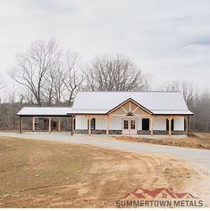 a large white building sitting on top of a dirt field