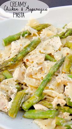 a white plate topped with pasta and asparagus