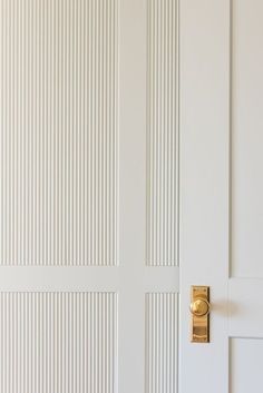 a white door with a gold handle on the front and side doors to another room