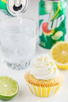 a cupcake with frosting next to a can of soda and lime wedges