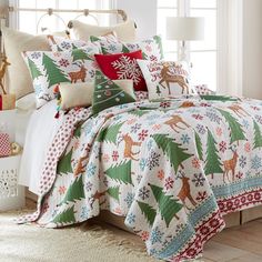 a bed with a christmas themed comforter and pillows