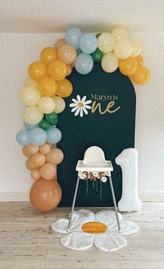 a baby's first birthday party with balloons and decorations, including a high chair