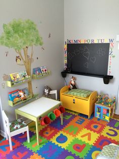 a child's playroom with toys, bookshelves and a chalkboard on the wall