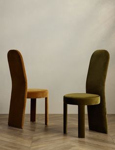 two chairs sitting next to each other on top of a wooden floor