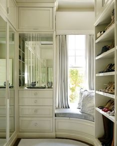 an image of a walk in closet with clothes and shoes on the shelves next to it