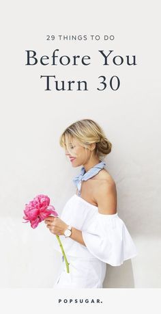 a woman holding a pink flower with the words 29 things to do before you turn 30