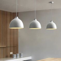 three pendant lights hanging over a kitchen counter