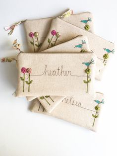 four embroidered name tags with flowers on them