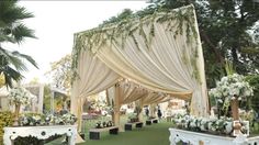 an outdoor wedding setup with white flowers and greenery