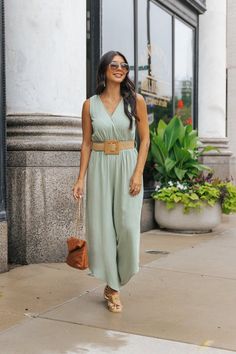 This Sleeveless Belted Jumpsuit is perfect for events like brunches, garden parties, or casual weddings! It's even versatile enough for shopping trips, casual meet-ups, or a day out in the city! Features a surplice v neckline, an asymmetrical hem, smocked waist, and an adjustable woven belt. Style it with flat sandals and a straw hat for a relaxed, casual look; or dress it up with statement jewelry and heels for a special night out. Summer Sleeveless Jumpsuit For Day Out, Sleeveless Summer Jumpsuits And Rompers For Brunch, Sleeveless Jumpsuits And Rompers For Spring Brunch, Versatile Spring Beach Jumpsuits And Rompers, Sleeveless Casual Jumpsuits And Rompers For Brunch, Casual Sleeveless Jumpsuits And Rompers For Brunch, Summer Sleeveless Jumpsuits And Rompers For Brunch, Summer Jumpsuits And Rompers For Garden Party, Elegant Green Spring Jumpsuits And Rompers