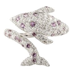 This is part of Chairish’s Fine Jewelry assortment.  Amethyst and Diamond Dolphin Ring in 18K Gold featuring natural amethyst of 0.35 carats and diamond of 1.13 carats. The gorgeous handcrafted ring goes with every style, every occasion or any outfit.  Amethyst encourages self-control and strengthens the bond in a relationship. Designed with round cut diamond studded all over the dolphin with amethyst in between the diamonds making a open ring of dolphin face on one side with tail on another tha Luxury Amethyst Ring With Brilliant Cut Diamond, Luxury Amethyst Diamond Ring With Brilliant Cut, Luxury White Gold Amethyst Ring With Diamond Accents, Luxury White Gold Amethyst Ring With Diamond, Luxury Purple Platinum Rings, Exquisite Purple Diamond Rings, Purple Pink Sapphire Rings With Brilliant Cut, Fine Jewelry Amethyst Diamond Ring With Accents, Amethyst Diamond Ring With Accents, Fine Jewelry