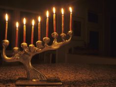 a silver menorah with five lit candles in it