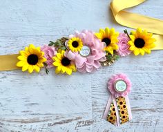 a yellow ribbon and some flowers on a white table