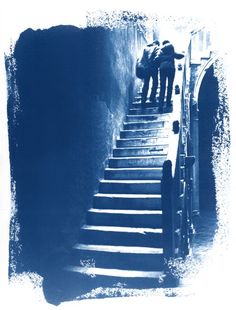 two people walking up some stairs in front of an open door and another person standing at the bottom