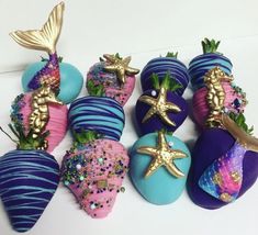 several chocolate covered strawberries decorated with sea creatures and starfish decorations on white surface