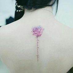 a woman's back with a pink rose tattoo on it