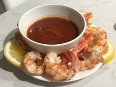 a white plate topped with shrimp and dipping sauce