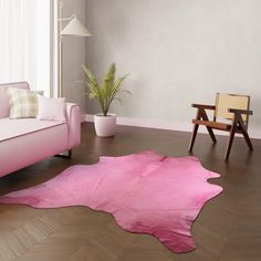 a living room with a pink couch, chair and rug on the floor in front of a window