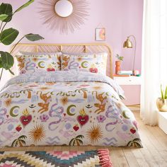 a bedroom with pink walls and colorful bedding