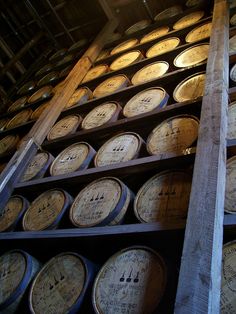 many wooden barrels are stacked on top of each other